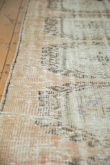 Worn texture of a vintage distressed Oushak runner, showing blush rose, ivory, and charcoal tones.