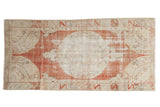 Distressed vintage Oushak runner, faded red medallion, neutral spandrels, serrated leaf border, 2'10