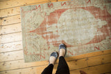 Faded pomegranate red roundel on antique ivory distressed Vintage Oushak runner.