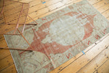 Vintage distressed Oushak runner corner with red quarter-medallion and leaf border.