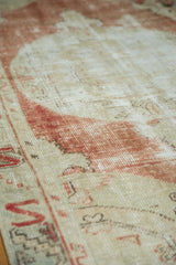 Decorative distressed texture of vintage Oushak runner, with low pile and faded pomegranate.