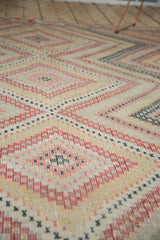 Hand-woven Jijim carpet's stepped diamond pattern with black cherry red, blush, and ivory hues.