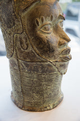 Profile of a vintage Benin prince head showing its detailed eye and textured collar.