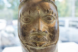 Detailed facial features and aged texture on a vintage African prince head sculpture.