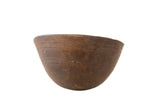 Vintage hand-carved African wooden bowl in dark brown with primitive texture and patina.