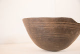 Primitive hand-carved vintage African bowl showing textured exterior and irregular rim.