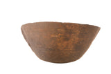 Vintage primitive African wooden bowl, dark brown with hand-carved rustic texture.