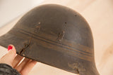 Aged dark wood surface with distinct cracks and metal repairs on the African bowl.