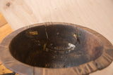 Hand-carved vintage African bowl interior, showcasing cracks and metal repairs.