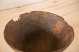 Detailed interior of vintage African bowl, showing a long crack and weathered, chipped rim.