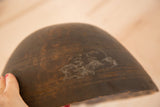 Close-up of vintage African wooden bowl, revealing dark wood, white marks, and aged patina.