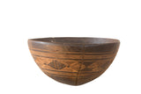 Vintage African wooden bowl, dark brown with hand-carved geometric patterns and a visible crack.