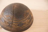 Dark wood vintage African bowl detail with wavy staple repair and carved patterns.