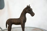Close-up detail of vintage African copper zebra sculpture's head with textured stripes.