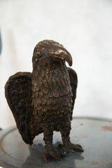 Detailed copper scales and taloned feet of the vintage African eagle sculpture.