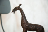 Detailed profile of a vintage copper giraffe's head showing textured circular patterns.