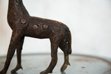 Carved circular spots and rustic texture on the vintage copper giraffe's body.