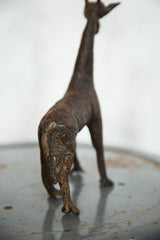 Detailed copper texture and aged patina on the back of a vintage giraffe.