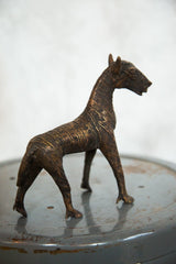 Aged copper zebra sculpture from the rear, showing textured stripes and detailed legs.