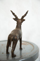 Vintage African Antelope sculpture, back view with twisted horns and time-softened copper finish.