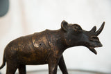 Detailed close-up of vintage copper rhino sculpture, with textured, dark patina.