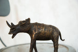 Vintage African rhino sculpture head and horn, showing aged copper texture.