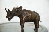 Vintage African copper rhino's textured back, detailed hind leg, and curled tail.