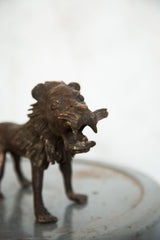 Close-up of vintage copper African lion sculpture's open mouth and textured mane.