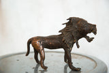 Detailed head of the vintage copper African lion sculpture with an open, roaring mouth.