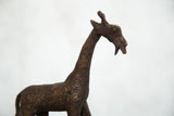 Close-up of the vintage copper giraffe sculpture's head and neck, with detailed circular patterns.