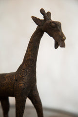 Textured copper giraffe sculpture detail with aged patina and circular motifs.