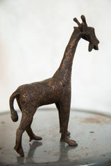 Close view of vintage copper giraffe with patterned body and detailed head.