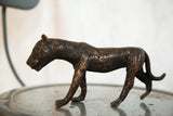 Vintage African copper tiger sculpture walking, displaying detailed etched lines and dark patina.
