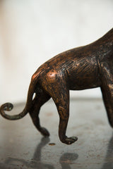 Vintage African monkey copper sculpture displaying textured hindquarters and a curled tail.