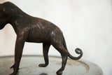 Vintage African copper monkey sculpture's textured body, hind legs, and curled tail.