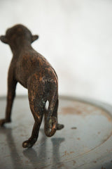 Vintage African copper monkey sculpture, textured back, hind legs, and coiled tail.