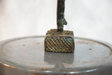 Textured copper base detail of the vintage African rooster, showing green patina.