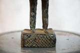 Aged copper legs, feet, and textured base of a vintage African rooster sculpture.