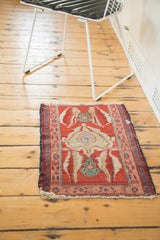 A small antique Persian Serapi rug showing its scale and asymmetric design in a home setting.