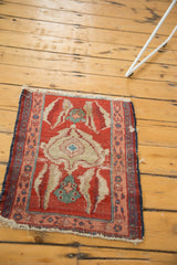 Angled perspective of the small antique Serapi mat, showcasing its authentic tatter and end loss.