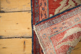 The hand-knotted foundation and secured side of an antique Serapi rug with a corner folded over.