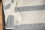 Textured hand-woven cotton spa towel in cream and light gray stripes.