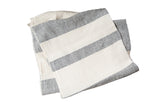 Hand-woven cotton spa towel with bold black and cream ticking stripes shown folded.