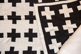Eco-Friendly reversible Swiss Cross blanket with black and ivory knit.