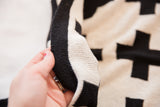 Eco-Friendly Baby Swiss Cross Blanket's reversible black and cream knit texture.