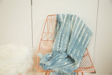 Hand woven indigo African textile throw with intricate white batik patterns and fringed edge.