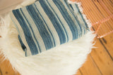 Folded vintage African indigo textile, featuring varied blue stripes and handwoven collectible texture.