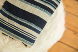 Hand-woven striped indigo African textile with detailed texture and variegated blue lines.