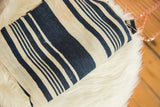 Folded striped indigo African textile with hand-woven texture and unique vintage character.