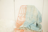 Draped vintage denim indigo African textile, highlighting its hand-woven texture and fringed end.